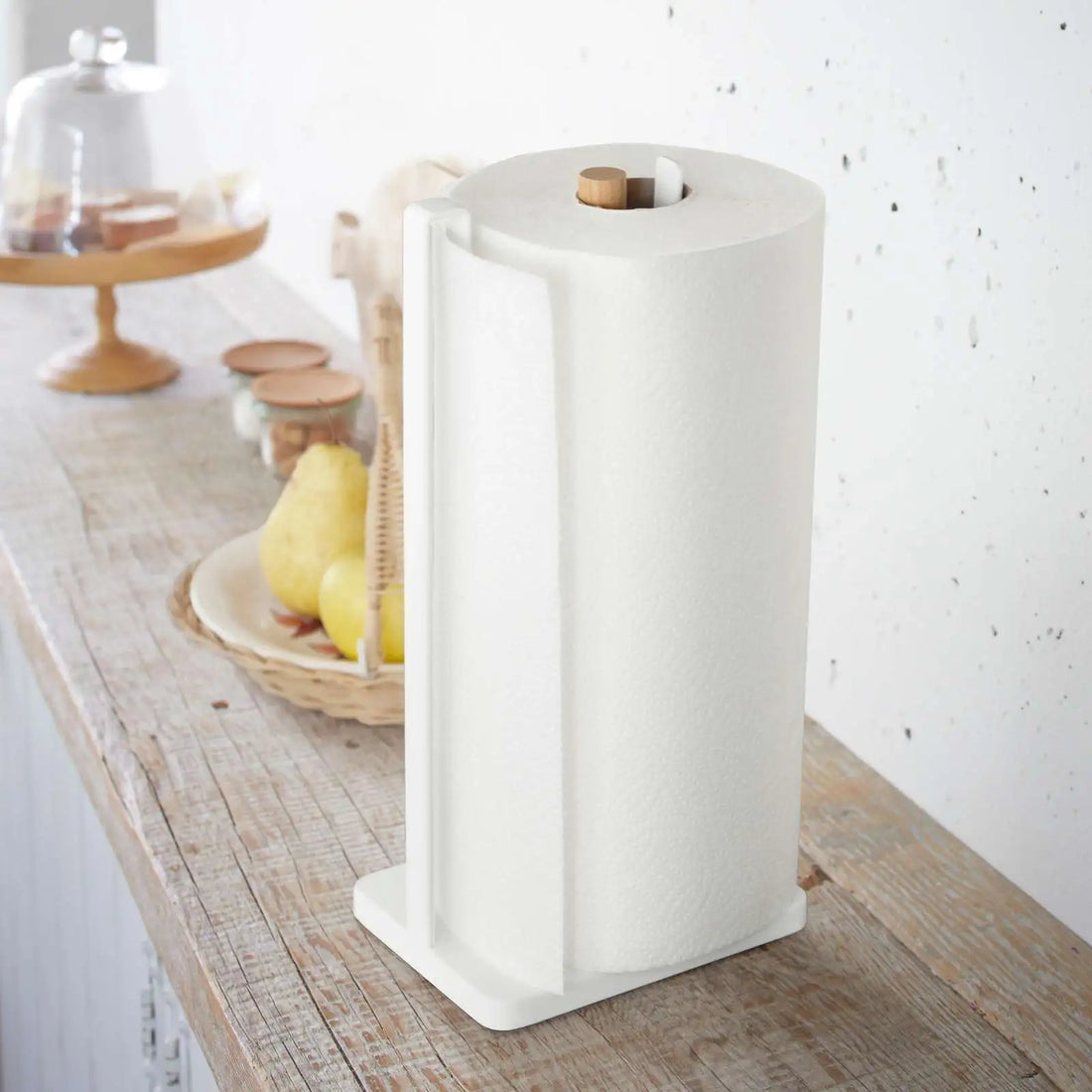 Küchenrollenhalter von Yamazaki in Weiss mit Holzstab, Küchenrolle sitzt stabil im Halter und wird über den seitlichen Bügel geführt.