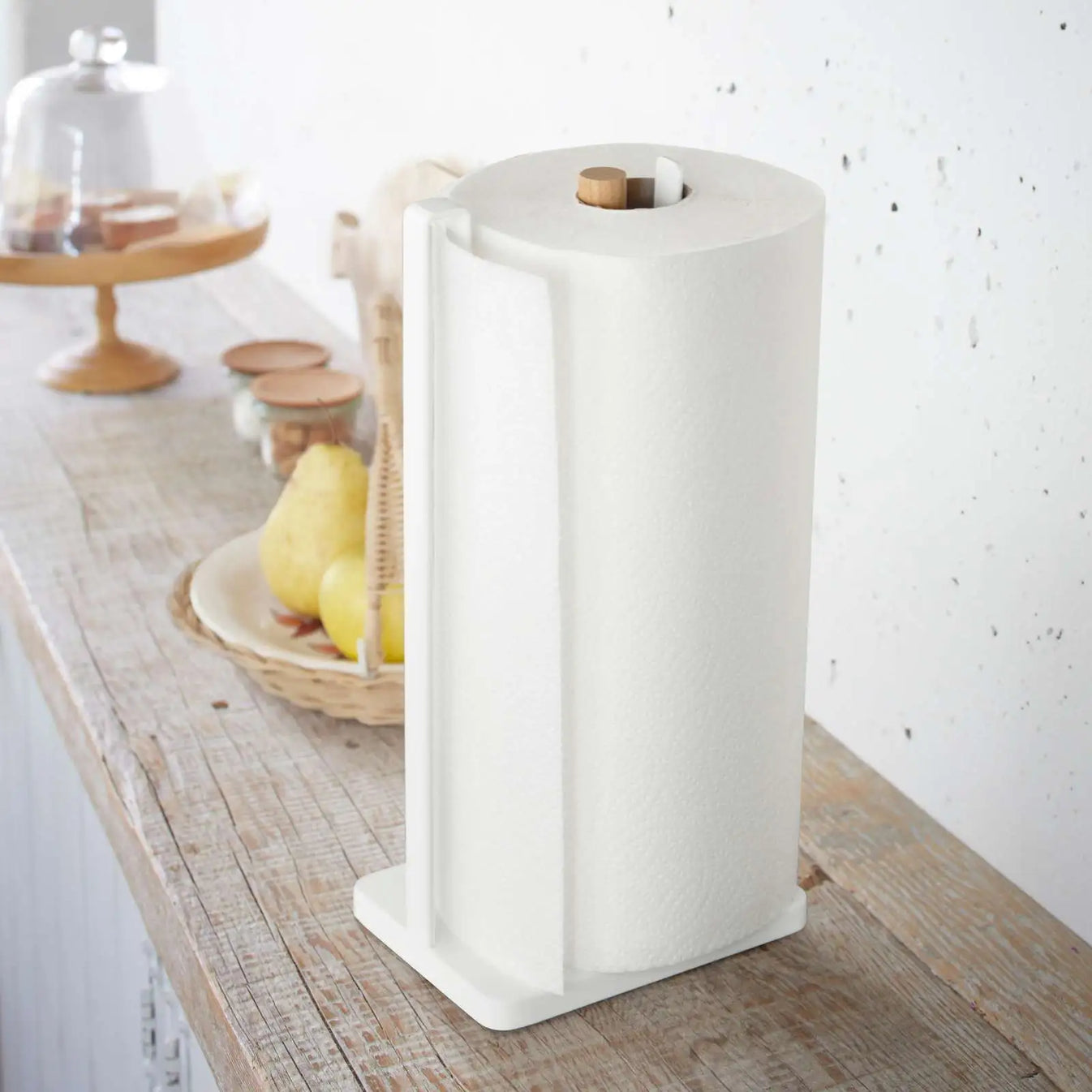 Küchenrollenhalter von Yamazaki in Weiss mit Holzstab, Küchenrolle sitzt stabil im Halter und wird über den seitlichen Bügel geführt.