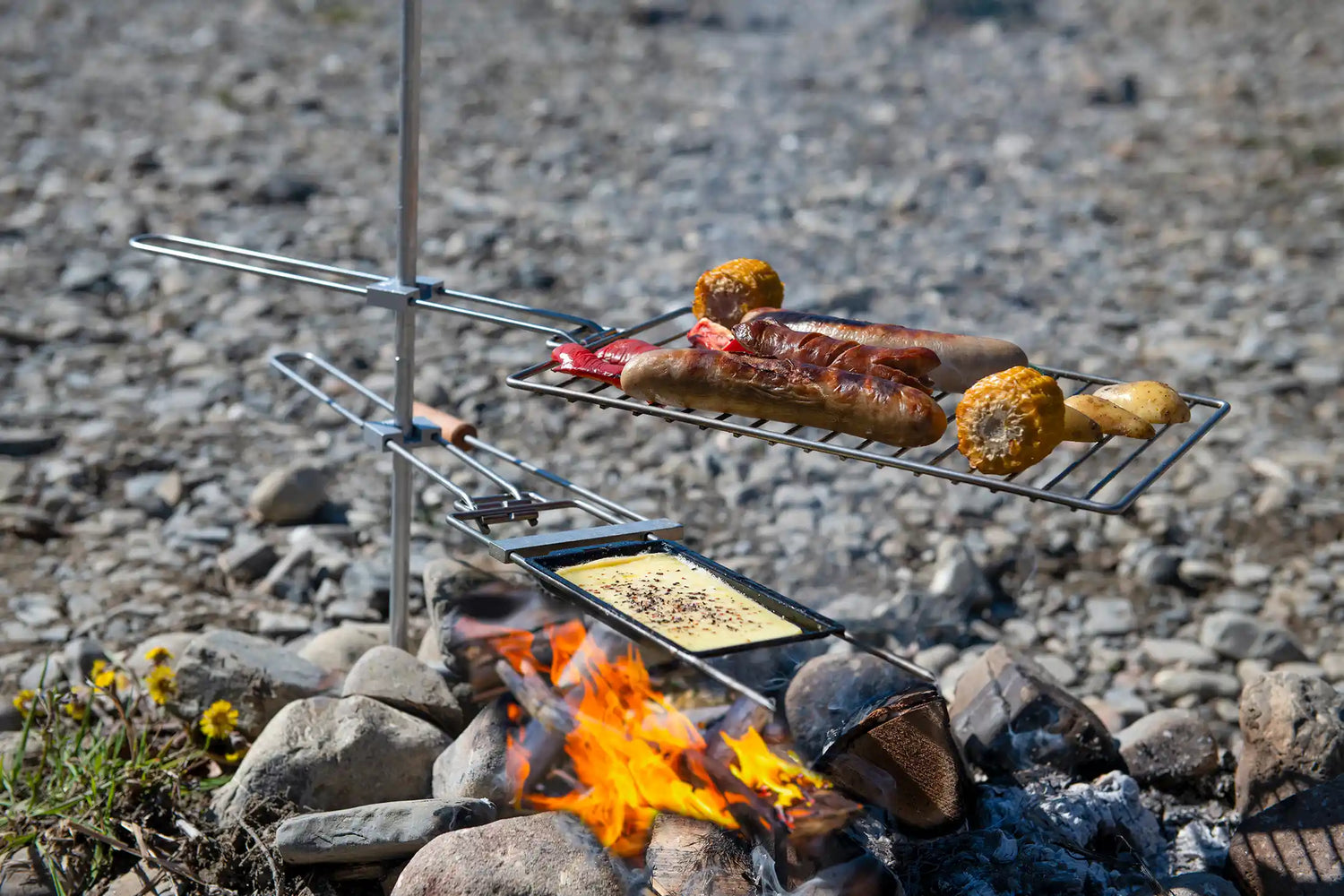 Mobiler Grill im Einsatz im Freien mit zubereiteten Speisen, ideal für spontanes Grillieren am See oder im Garten.