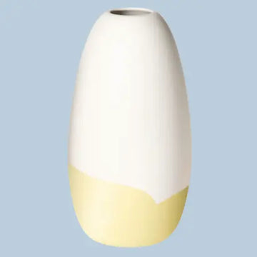 Konische Porzellanvase „Iapetus - hellgelb“, seidenmatt weiss glasiert mit hellgelbem Akzent am unteren Bereich, freigestellt vor hellblauem Hintergrund.