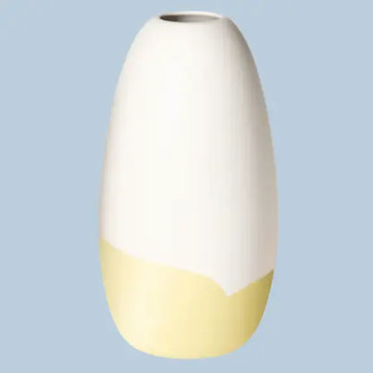 Konische Porzellanvase „Iapetus - hellgelb“, seidenmatt weiss glasiert mit hellgelbem Akzent am unteren Bereich, freigestellt vor hellblauem Hintergrund.