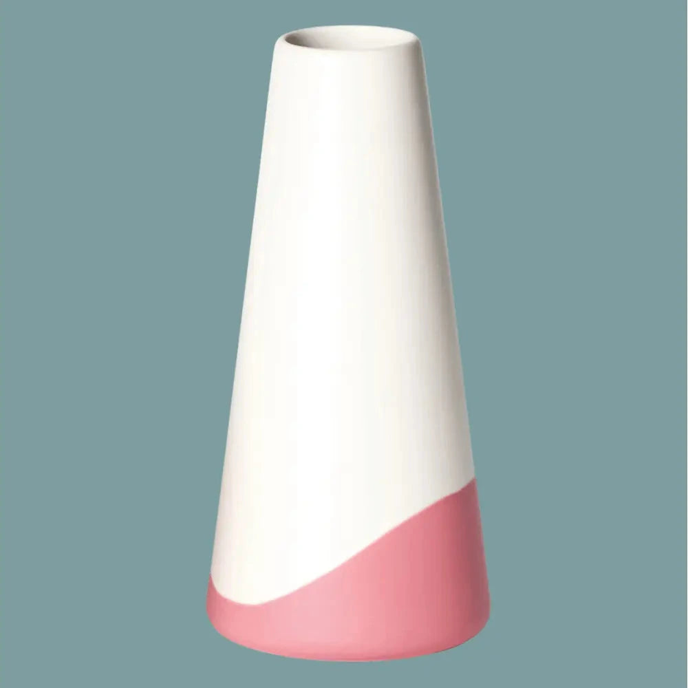 Handgefertigte Porzellanvase „Neptun“ in Weiss mit rotfarbenem Farbschwung am Fuss, freigestellt vor petrolfarbenem Hintergrund.