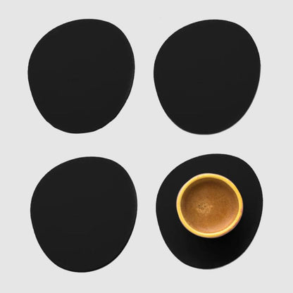Ruca Stone Coasters Black als Getränkeuntersetzer: 4er Set, ein Untersetzer mit Espressotasse von oben, neutraler Hintergrund.